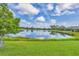 Expansive lake view showcasing lush green lawn and blue skies at 213 Malina Ct, Nokomis, FL 34275
