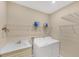 Well lit laundry room features washer and dryer hookups, shelving, and utility sink at 213 Malina Ct, Nokomis, FL 34275