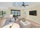 Bright living room with tile flooring, lake view, and comfortable furniture in a modern design at 213 Malina Ct, Nokomis, FL 34275