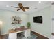 Bright office features a ceiling fan, desk, floating shelves and light green walls at 213 Malina Ct, Nokomis, FL 34275