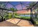A screened patio with a beautiful view of the lake and lush greenery, ideal for outdoor relaxation and entertaining at 213 Malina Ct, Nokomis, FL 34275