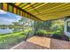 Outdoor patio with a retractable awning overlooking a tranquil lake, providing a versatile space for relaxation and entertainment at 213 Malina Ct, Nokomis, FL 34275