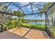 Screened-in patio with stunning lake views and lush landscaping, offering an ideal space for outdoor relaxation and leisure at 213 Malina Ct, Nokomis, FL 34275