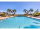 Resort swimming pool with sun loungers and lush tropical vegetation on a sunny day at 213 Malina Ct, Nokomis, FL 34275
