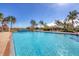 Bright swimming pool with sun loungers and palm trees in a resort setting at 213 Malina Ct, Nokomis, FL 34275