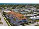 An aerial view of a beautiful condo complex with a terracotta roof, surrounded by lush greenery and palm trees at 235 Base E Ave # 207, Venice, FL 34285