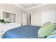 Spacious bedroom featuring white dresser with mirror and blue quilted bed at 235 Base E Ave # 207, Venice, FL 34285