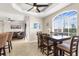 A cozy dining area features a modern table setting and large windows, seamlessly connecting to the kitchen and living room at 235 Base E Ave # 207, Venice, FL 34285