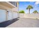An inviting exterior of a residence with white doors, a paved parking area, and a well-maintained yard at 235 Base E Ave # 207, Venice, FL 34285