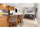 A modern open kitchen with bar seating seamlessly connects to a spacious living area, perfect for entertaining at 235 Base E Ave # 207, Venice, FL 34285