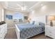 Bright primary bedroom features a tray ceiling, ceiling fan, and an arched window at 235 Base E Ave # 207, Venice, FL 34285