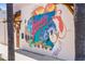 Colorful mural featuring dolphins and Florida imagery enhances the exterior of the building with artistic flair at 235 Base E Ave # 207, Venice, FL 34285