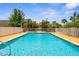 Community pool with wooden deck and fencing at 235 Base E Ave # 207, Venice, FL 34285
