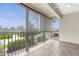 Relaxing porch with tile flooring, railing, and views of the surrounding greenery at 235 Base E Ave # 207, Venice, FL 34285