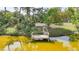 Aerial view of the property with a dock, boat and waterfront access surrounded by mature trees at 249 Hallcrest Ter, Port Charlotte, FL 33954