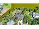 Aerial view of a home with a swimming pool surrounded by green trees, grass, and a lake at 249 Hallcrest Ter, Port Charlotte, FL 33954