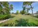 Expansive lawn and landscaping in the backyard with water views and mature trees create a private oasis at 249 Hallcrest Ter, Port Charlotte, FL 33954