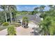 Charming yellow house featuring a well-manicured lawn, palm trees, and a circular driveway at 249 Hallcrest Ter, Port Charlotte, FL 33954