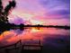 Picturesque sunset reflecting on the lake, viewed from a wooden dock, creating a tranquil ambiance at 249 Hallcrest Ter, Port Charlotte, FL 33954
