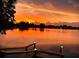 Scenic lake view with a wooden dock, reflecting the vibrant colors of the sunset sky at 249 Hallcrest Ter, Port Charlotte, FL 33954