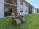 Condo backyard featuring lawn, screened-in patio, and lawn chairs at 25050 Sandhill Blvd # 6A3, Punta Gorda, FL 33983