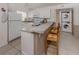 Kitchen features a breakfast bar, white appliances and cabinetry with stacked washer and dryer at 25050 Sandhill Blvd # 6A3, Punta Gorda, FL 33983