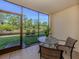 Screened lanai featuring outdoor seating and a view of the lush green lawn and pond at 25050 Sandhill Blvd # 6A3, Punta Gorda, FL 33983