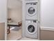 Hallway laundry closet featuring a stacked washer and dryer, with bedroom visible through door at 25050 Sandhill Blvd # 6A3, Punta Gorda, FL 33983
