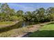Calm pond surrounded by lush greenery and trees, creating a serene and natural view at 25050 Sandhill Blvd # 6A3, Punta Gorda, FL 33983