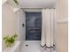 Shower with blue tiled backsplash, bronze shower head and grab bar, and white shower curtain at 25050 Sandhill Blvd # 6A3, Punta Gorda, FL 33983