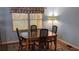 This dining room has light blue walls, a wooden table, four chairs and a patterned rug at 310 Tropic Dr, Osprey, FL 34229