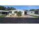 Front exterior view of cozy home featuring an attached carport and tidy landscaping at 310 Tropic Dr, Osprey, FL 34229