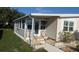 Home exterior featuring an enclosed porch, easy access ramp, and manicured landscaping at 310 Tropic Dr, Osprey, FL 34229