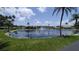 Scenic pond with a central fountain, surrounded by lush green lawns, and community homes in background at 310 Tropic Dr, Osprey, FL 34229