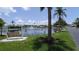 Beautiful pond featuring a fountain, swing bench, and lush landscaping with palm trees at 310 Tropic Dr, Osprey, FL 34229