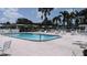 Community pool with plenty of lounge chairs, tables, and surrounding well-maintained deck and fence at 310 Tropic Dr, Osprey, FL 34229
