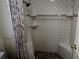 Updated tile shower with built-in seating and decorative shower curtain at 310 Tropic Dr, Osprey, FL 34229