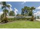 Beautiful community sign for Harbor Isles with lush landscaping, palm trees, and a blue sky backdrop at 349 Mariner Dr, North Port, FL 34287