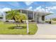 Charming home exterior features manicured landscaping, a covered carport, and a welcoming entrance at 349 Mariner Dr, North Port, FL 34287