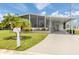 Inviting single-story home with a well-manicured lawn, covered parking, and a screened-in porch area at 349 Mariner Dr, North Port, FL 34287