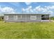 Charming single-story home with well-maintained lawn, gray siding, and a sunroom on a sunny day at 349 Mariner Dr, North Port, FL 34287
