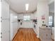 A bright, galley kitchen features white appliances and cabinets, and a window overlooking the home's exterior at 349 Mariner Dr, North Port, FL 34287
