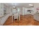 Bright kitchen flows into dining area with wood floors, white cabinets, and matching appliances for a seamless design at 349 Mariner Dr, North Port, FL 34287