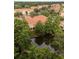 Aerial view of townhome complex with an orange tiled roof, landscaping, and a scenic pond at 3613 Parkridge Cir # 11-201, Sarasota, FL 34243