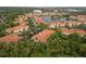 Aerial view of a townhome community featuring orange tile roofs, lush landscaping, and a serene lake with fountain at 3613 Parkridge Cir # 11-201, Sarasota, FL 34243