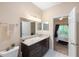 Well-lit bathroom featuring a granite vanity, wood cabinets, and an open doorway to the bedroom at 3613 Parkridge Cir # 11-201, Sarasota, FL 34243