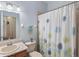 Bathroom showcasing a shower with a floral curtain, along with the vanity and toilet at 3613 Parkridge Cir # 11-201, Sarasota, FL 34243