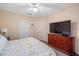 This bedroom features neutral walls, bedside lamps, and a large dresser with TV at 3613 Parkridge Cir # 11-201, Sarasota, FL 34243