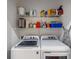Functional laundry room featuring a washer, dryer, shelving, and laundry supplies for added convenience at 3613 Parkridge Cir # 11-201, Sarasota, FL 34243
