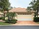 Charming single-story home featuring a tile roof, lush landscaping, and a two-car garage with an attractive brick driveway at 3790 Cadbury Cir # 40, Venice, FL 34293